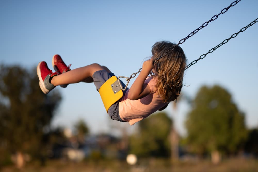 Young girl swinging with their back to the camera